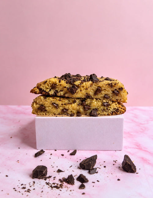 Cookie chocolat noir ouvert sur fond rose poudré